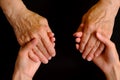 Hands of young woman holding hands of an elderly woman Royalty Free Stock Photo