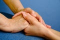 Hands of young woman holding hands of an elderly woman Royalty Free Stock Photo