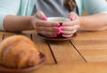 Young woman with pink manicure holding a cup of green tea, no face Royalty Free Stock Photo