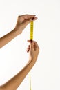 hands of a young woman holding a tape measure, white background. Royalty Free Stock Photo