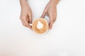 Hands of a young woman holding a vintage cup with hot tasty coffee in a cafe. Top view on a cappuccino in female hands on a white Royalty Free Stock Photo