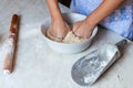 Hands of a young woman, kneading dough to make bread or pizza at home. Production of flour products. Making dough by Royalty Free Stock Photo