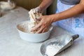 Hands of a young woman, kneading dough to make bread or pizza at home. Production of flour products. Making dough by Royalty Free Stock Photo