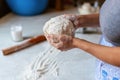 Hands of a young woman, kneading dough to make bread or pizza at home. Production of flour products. Making dough by Royalty Free Stock Photo