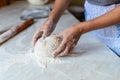 Hands of a young woman, kneading dough to make bread or pizza at home. Production of flour products. Making dough by Royalty Free Stock Photo