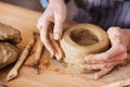 Hands of young woman making earthen pot on wooden table Royalty Free Stock Photo