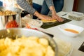 Hands of young woman making venezuelan christmas dish hallacas with all ingredients on table Royalty Free Stock Photo