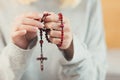 Hands young woman prays to God, folded her arms on her chest uses a rosary and a crucifix