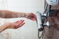 Hands of a young woman taking a hot shower