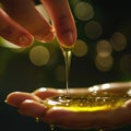 Hands of a young woman touching a drop of olive oil on a dark background