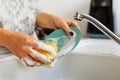 Hands young woman washing dirty dishes in kitchen sink with washcloth and detergent Royalty Free Stock Photo