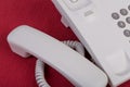 Handset gray phone.Push-button telephone is on a red background