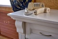 The handset of a push-button phone lies on a white vintage table. The concept of telephone conversations at the highest