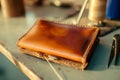 handsewing a leather wallet with waxed thread on a table Royalty Free Stock Photo