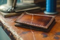handsewing a leather wallet with waxed thread on a table Royalty Free Stock Photo