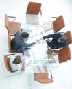 Handshake across the table. Meeting around a boardroom table. Royalty Free Stock Photo