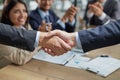 Handshake in agreement against young business people in board room meeting Royalty Free Stock Photo