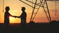 handshake agriculture. silhouette two farmers sign a contract shake hands on the background of an irrigation machine in