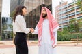 Handshake of arab sheikh man and european business woman at outdoor meeting Royalty Free Stock Photo