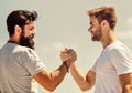 Handshake arm wrestling style. Strong and muscular arms. Successful deal handshake blue sky background. Men shaking Royalty Free Stock Photo