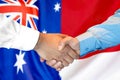 Handshake on Australia and Monaco flag background