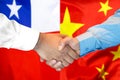 Handshake on Chile and China flag background