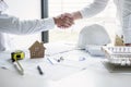 Handshake of collaboration, Construction engineering or architect discuss a blueprint and building model while checking Royalty Free Stock Photo