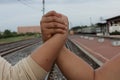 Handshake conveys good friendship in the train station background.