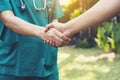 Handshake between doctor green cloth and patient