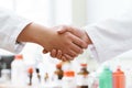 Handshake doctors or scientists against blurred background