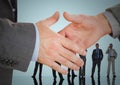 Handshake in front of business people with blue background Royalty Free Stock Photo