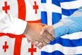 Handshake on Georgia and Greece flag background