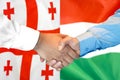 Handshake on Georgia and Hungary flag background