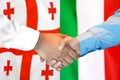 Handshake on Georgia and Italy flag background