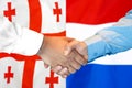 Handshake on Georgia and Netherlands flag background