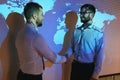 Handshake with map of the world in background. two businessmen on the background of the world map shake hands, the Royalty Free Stock Photo