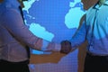 Handshake with map of the world in background. two businessmen on the background of the world map shake hands, the Royalty Free Stock Photo