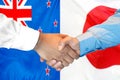 Handshake on New Zealand and Japan flag background