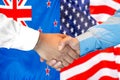 Handshake on New Zealand and US flag background