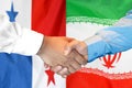 Handshake on Panama and Iran flag background