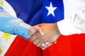 Handshake on Philippines and Chile flag background