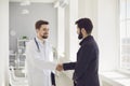 Handshake. Practicing doctor and patient shaking hands smiling at the clinic. Royalty Free Stock Photo