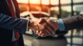 Handshake between a professional seller and an excited buyer at a car dealership. This image represents the successful completion