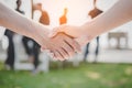 Handshake of two business people at outdoors. Business and Nature concept. Meeting and Partnership theme. Blurry people in Royalty Free Stock Photo