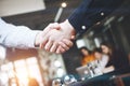 Handshake of two businessmen close-up, on a background of modern loft office