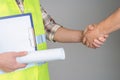 The handshake of two men. The concept of a business agreement between the builder and the customer on a gray background