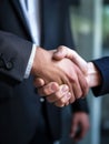 A handshake of two men. Unrecognized businessmen wearing suits shake hands agreeing on something or greeting each other. Close up