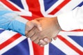 Handshake on United Kingdom flag background Royalty Free Stock Photo