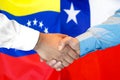 Handshake on Venezuela and Chile flag background