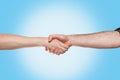 Handshake of a woman and a man on a blue background. Close up and copy space.Concept of viral pandemic, disinfection and